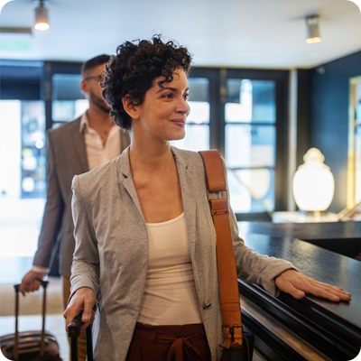 Business travelers arriving at hotel reception desk