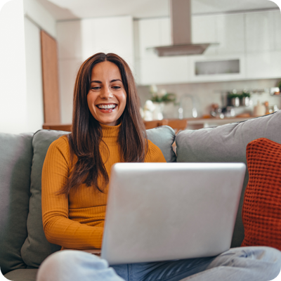 Happy Woman Relaxing At Home And Using Laptop In Living Room