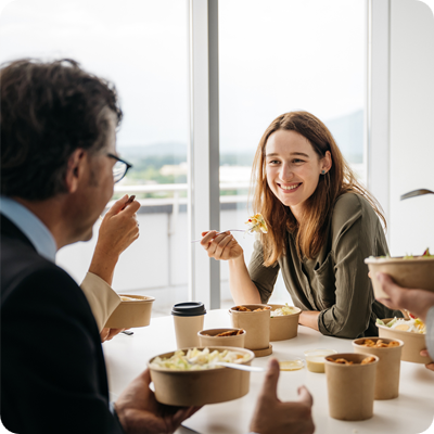 A smiling woman enjoying lunch with her colleagues