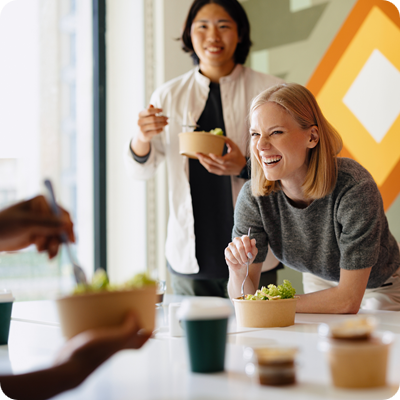 Diverse Group Sharing a Meal in a Modern Business Environment