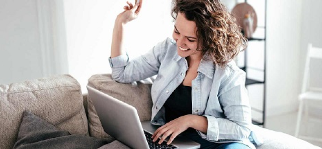 Woman laughing and using a computer