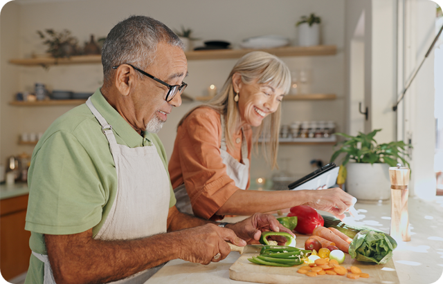 Two elderly people cooking together