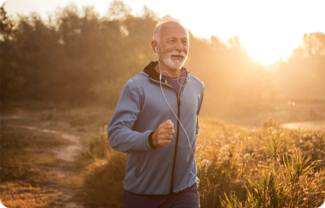 Mature man jogging in by lake in morning time