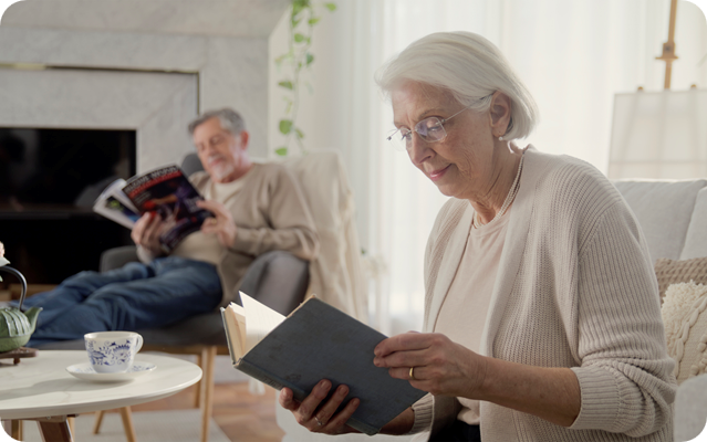 Senior woman reading book in living room