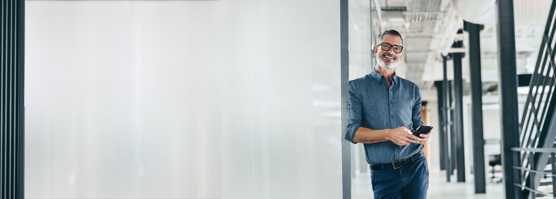 Business man standing in the office and smiling.